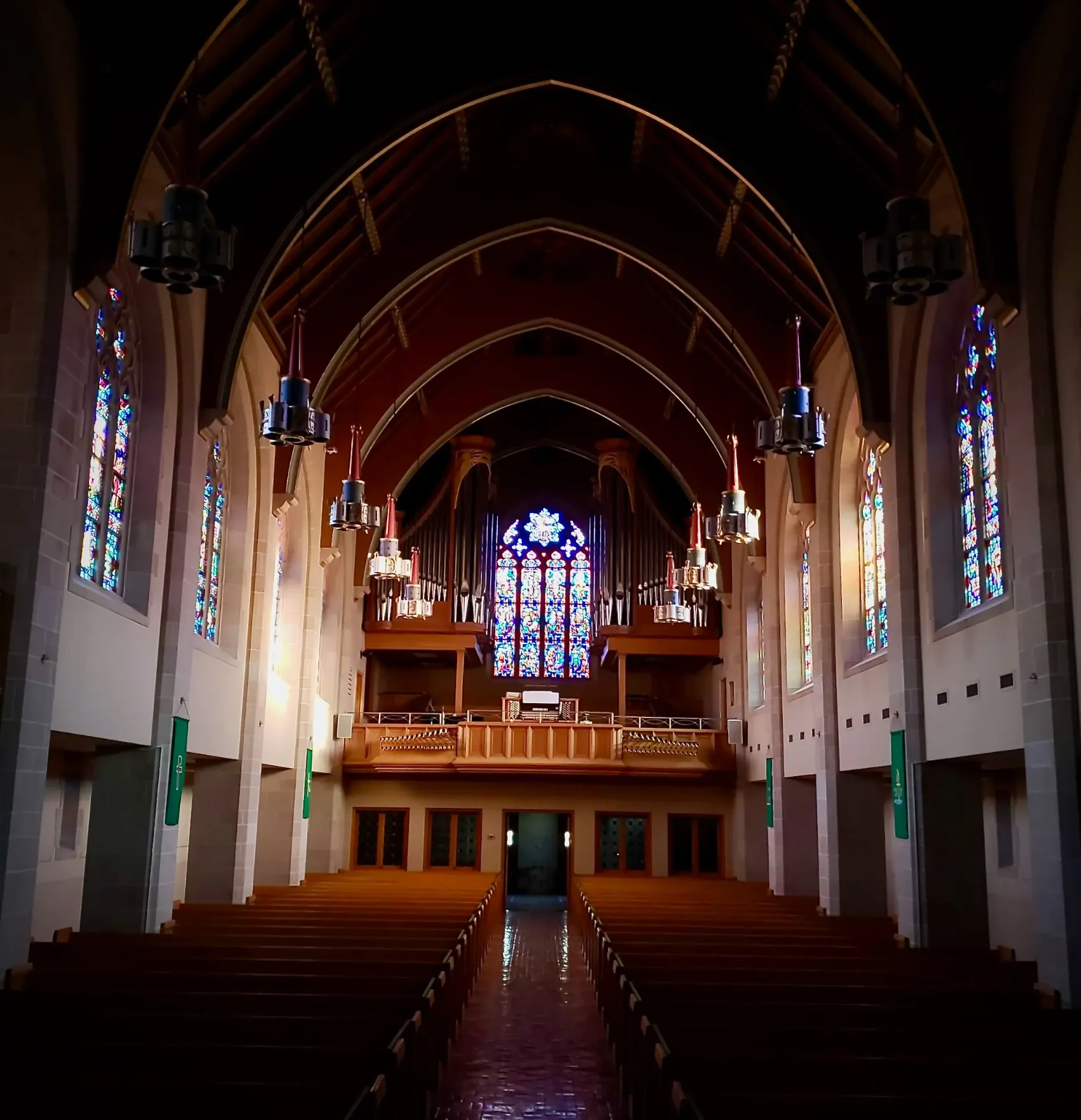 The nave of Zion Lutheran Church looking toward the rear balcony, pipe organ, and great stained-glass window